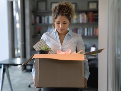 a woman leaving her job with her items in a box